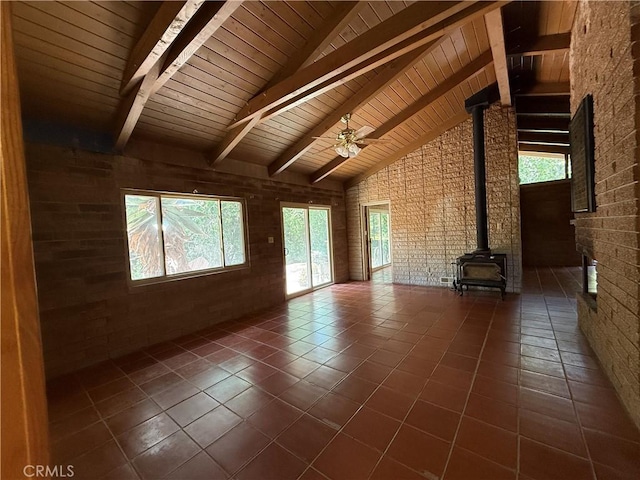 11955 Santa Lucia Rd, Atascadero, CA 93422 - unfurnished living room with a wood stove, plenty of natural light, dark tile patterned floors, a ceiling fan, and high vaulted ceiling