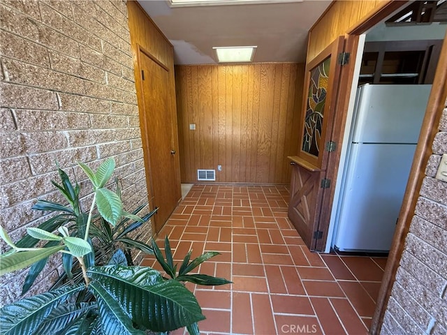 11955 Santa Lucia Rd, Atascadero, CA 93422 - interior space with freestanding refrigerator, wood walls, brick patterned floors, and brown cabinetry