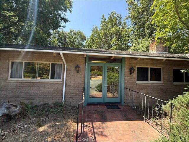11955 Santa Lucia Rd, Atascadero, CA 93422 - view of exterior entry featuring french doors, a chimney, and brick siding