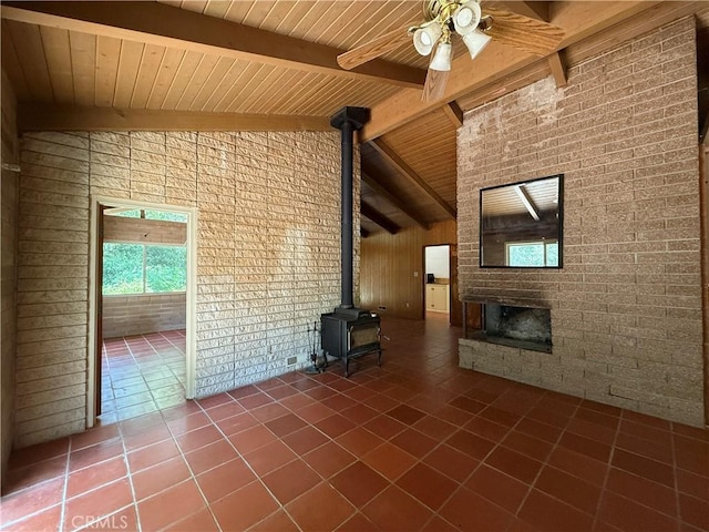 11955 Santa Lucia Rd, Atascadero, CA 93422 - unfurnished living room with a wood stove, tile patterned floors, ceiling fan, a wood ceiling with exposed beams, and brick wall