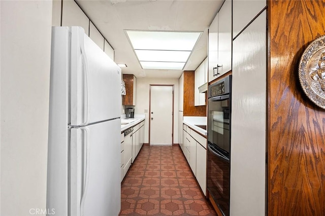 1500 Country Club Dr, Riverside, CA 92506 - kitchen featuring freestanding refrigerator, light countertops, white cabinets, and dark floors