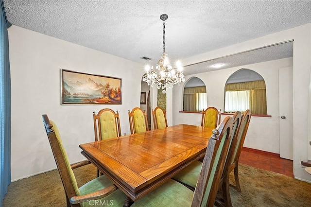 1500 Country Club Dr, Riverside, CA 92506 - dining area featuring a chandelier, a textured ceiling, carpet, and arched walkways