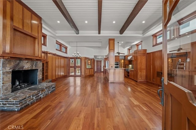 401 8th St, Manhattan Beach, CA 90266 - unfurnished living room with a ceiling fan, a stone fireplace, light wood finished floors, beamed ceiling, and healthy amount of natural light