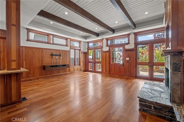 401 8th St, Manhattan Beach, CA 90266 - unfurnished living room featuring a fireplace with raised hearth, light wood finished floors, french doors, wood walls, and a wainscoted wall
