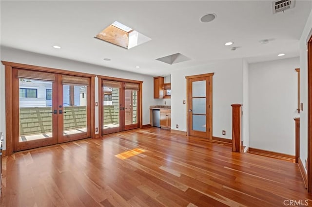 401 8th St, Manhattan Beach, CA 90266 - unfurnished living room with french doors, a skylight, light wood finished floors, plenty of natural light, and recessed lighting
