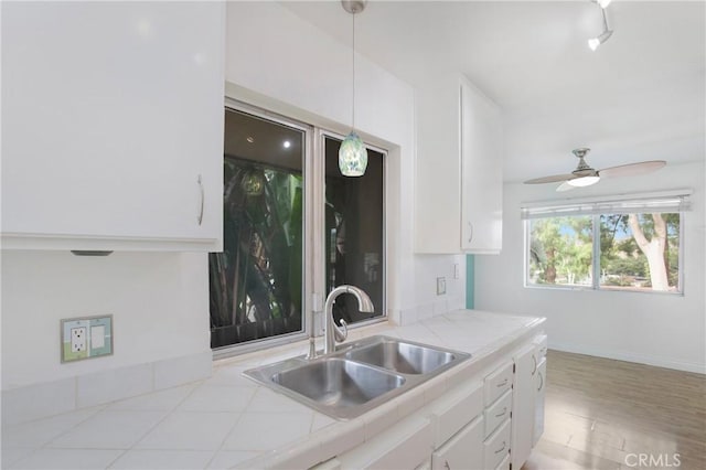 23372 Caminito Marcial Unit 187, Laguna Hills, CA 92653 - kitchen with white cabinets, tile counters, and a ceiling fan