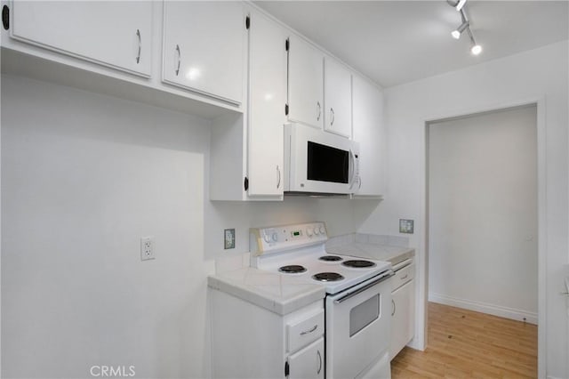 23372 Caminito Marcial Unit 187, Laguna Hills, CA 92653 - kitchen with white appliances, white cabinetry, and light wood-style flooring