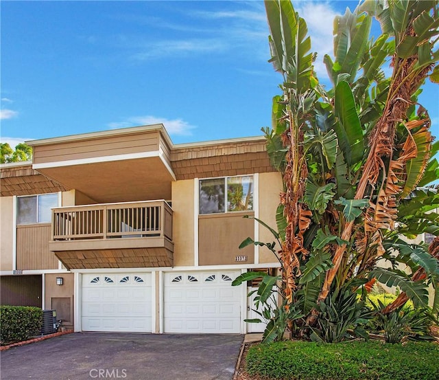 23372 Caminito Marcial Unit 187, Laguna Hills, CA 92653 - view of front facade with asphalt driveway, a balcony, and a garage