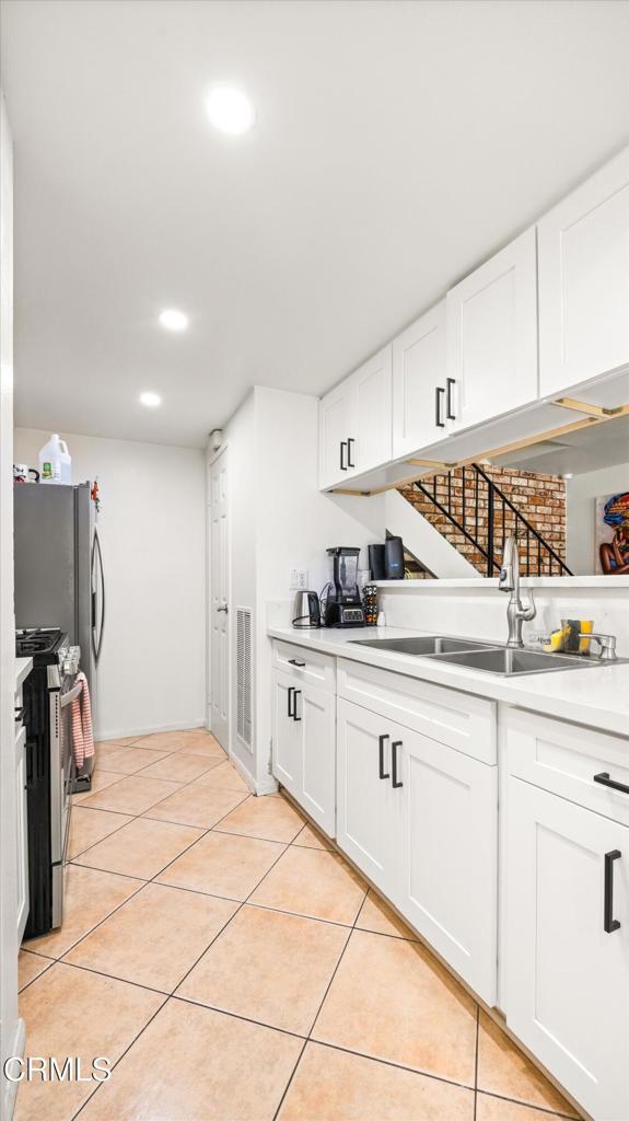 1222 Acadia Pl, Ventura, CA 93003 - kitchen with appliances with stainless steel finishes, light tile patterned floors, light countertops, white cabinets, and recessed lighting