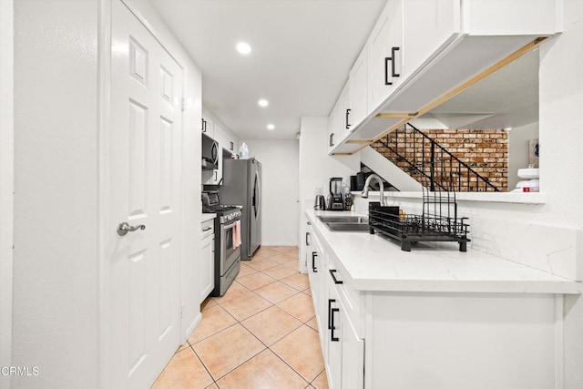1222 Acadia Pl, Ventura, CA 93003 - kitchen featuring appliances with stainless steel finishes, recessed lighting, white cabinetry, light tile patterned flooring, and light stone countertops