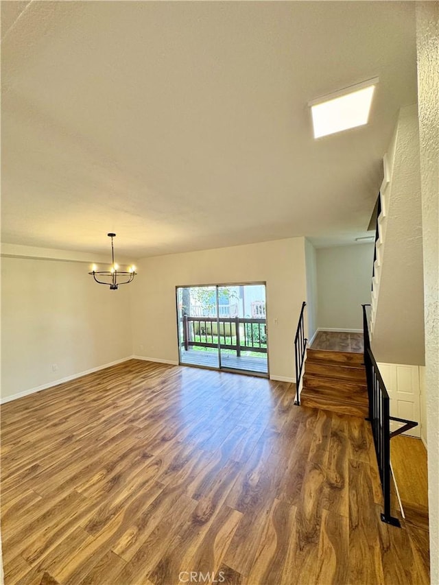 9010 Burke St Unit 22, Pico Rivera, CA 90660 - unfurnished living room featuring stairway, wood finished floors, and a chandelier