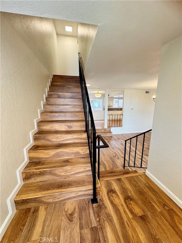 9010 Burke St Unit 22, Pico Rivera, CA 90660 - stairway featuring wood finished floors and a textured wall