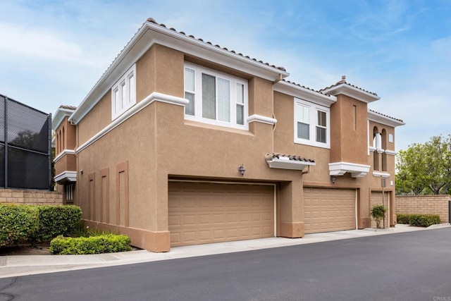 12625 Fiorenza Ln Unit 236, San Diego, CA 92128 - view of front of home with an attached garage, stucco siding, and a tiled roof