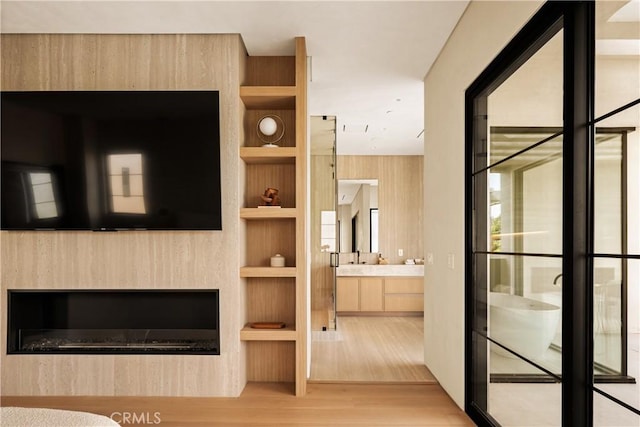 4724 Lemona Ave, Sherman Oaks, CA 91403 - unfurnished living room featuring wood finished floors, built in shelves, and a glass covered fireplace