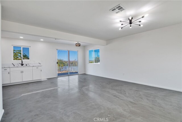 61638 La Jolla Dr, Joshua Tree, CA 92252 - unfurnished living room with finished concrete floors, a chandelier, and recessed lighting