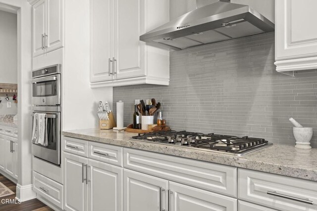 508 Autumn Path Ln, Santa Paula, CA 93060 - kitchen with wall chimney range hood, stainless steel appliances, white cabinetry, tasteful backsplash, and light stone countertops