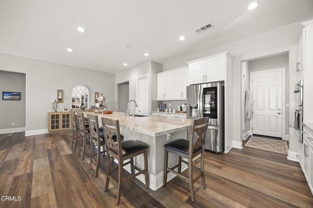 508 Autumn Path Ln, Santa Paula, CA 93060 - kitchen with appliances with stainless steel finishes, dark wood finished floors, recessed lighting, light stone countertops, and white cabinets