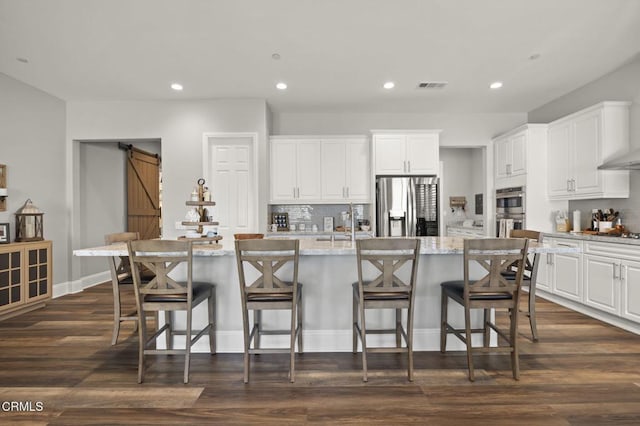 508 Autumn Path Ln, Santa Paula, CA 93060 - kitchen featuring appliances with stainless steel finishes, a barn door, decorative backsplash, recessed lighting, and white cabinetry