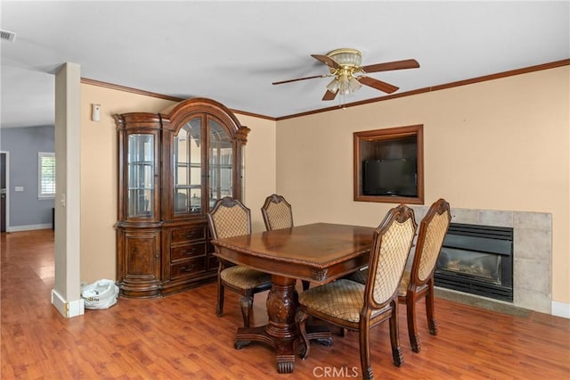 2306 Apion Ct, Paso Robles, CA 93446 - dining area with a ceiling fan, wood finished floors, crown molding, and a fireplace