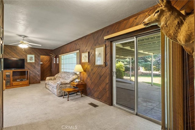 1603 Colusa St, Corning, CA 96021 - carpeted living room featuring wooden walls, a ceiling fan, and a textured ceiling