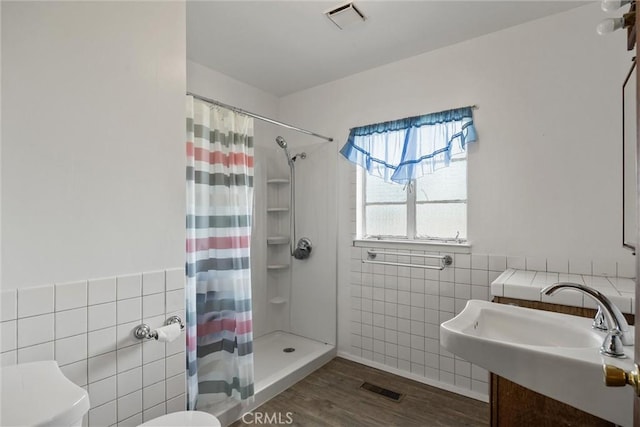 1603 Colusa St, Corning, CA 96021 - full bathroom featuring tile walls, wood finished floors, and a shower with curtain