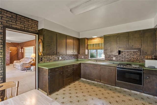 1603 Colusa St, Corning, CA 96021 - kitchen featuring electric range, plenty of natural light, dark brown cabinetry, wood walls, and light countertops
