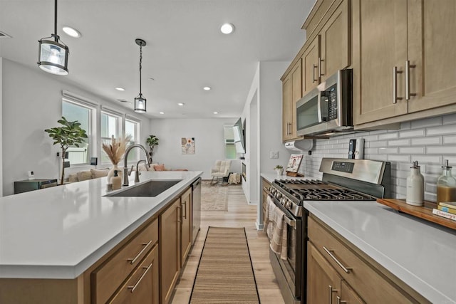 32755 Brunello Way, Temecula, CA 92591 - kitchen featuring appliances with stainless steel finishes, open floor plan, decorative backsplash, light wood-style flooring, and recessed lighting