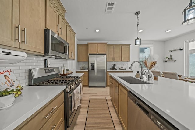 32755 Brunello Way, Temecula, CA 92591 - kitchen with stainless steel appliances, light countertops, light wood finished floors, recessed lighting, and decorative backsplash