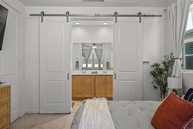 32755 Brunello Way, Temecula, CA 92591 - bedroom featuring a barn door, light carpet, ensuite bathroom, and recessed lighting
