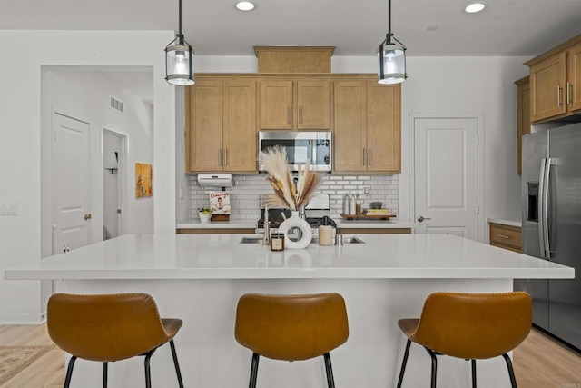 32755 Brunello Way, Temecula, CA 92591 - kitchen with appliances with stainless steel finishes, a kitchen bar, backsplash, light countertops, and recessed lighting