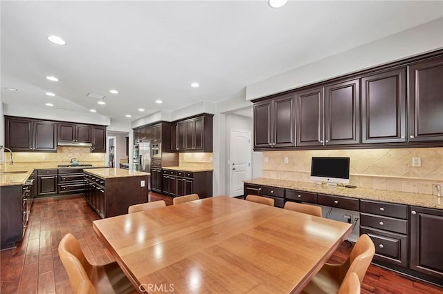46379 Canyon Crest Ct, Temecula, CA 92592 - kitchen featuring dark brown cabinetry, backsplash, a center island, stainless steel gas cooktop, and dark wood-style floors