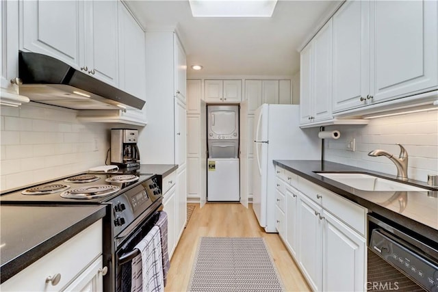 3205 Via Buena Unit B, Laguna Woods, CA 92637 - kitchen with black appliances, stacked washer / dryer, under cabinet range hood, and dark countertops