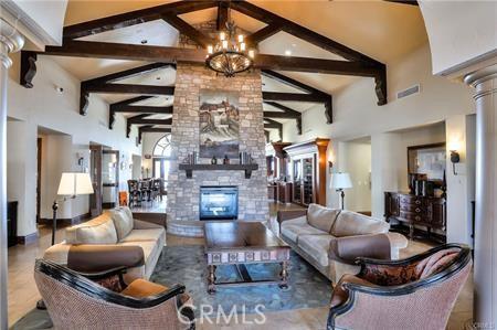 3205 Via Buena Unit B, Laguna Woods, CA 92637 - living room featuring a fireplace, high vaulted ceiling, beamed ceiling, a chandelier, and decorative columns
