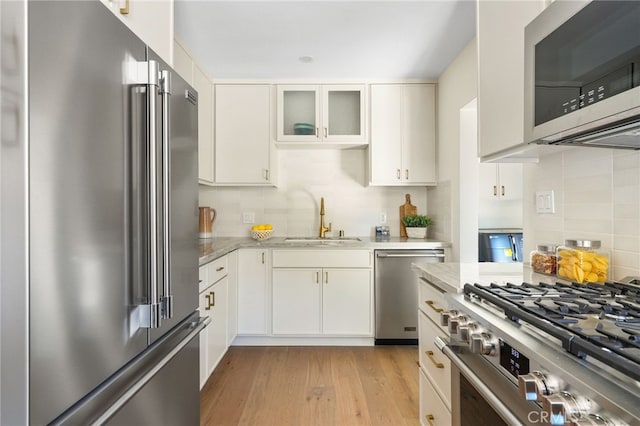 2721 184th St, Redondo Beach, CA 90278 - kitchen featuring high end appliances, tasteful backsplash, light stone countertops, white cabinetry, and light wood-type flooring