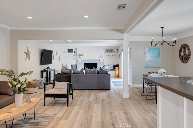 19125 Anza Ave, Torrance, CA 90503 - living room with crown molding, light wood finished floors, a chandelier, a fireplace, and recessed lighting