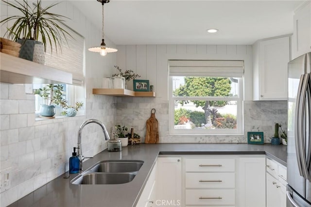 19125 Anza Ave, Torrance, CA 90503 - kitchen featuring freestanding refrigerator, decorative backsplash, white cabinetry, dark countertops, and hanging light fixtures