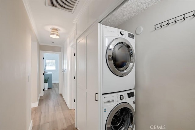 19125 Anza Ave, Torrance, CA 90503 - laundry area with stacked washing machine and dryer, crown molding, and light wood-style floors
