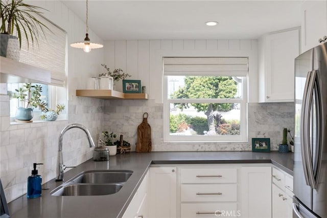 19125 Anza Ave, Torrance, CA 90503 - kitchen featuring freestanding refrigerator, white cabinets, backsplash, dark countertops, and decorative light fixtures