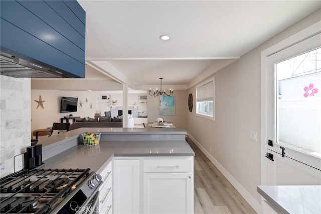 19125 Anza Ave, Torrance, CA 90503 - kitchen with a chandelier, light wood-style floors, white cabinetry, open floor plan, and a peninsula