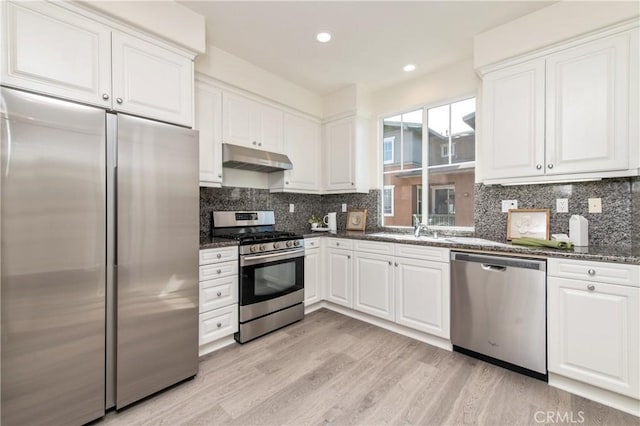 357 Flyers Ln, Tustin, CA 92782 - kitchen featuring appliances with stainless steel finishes, under cabinet range hood, white cabinetry, light wood-style floors, and recessed lighting