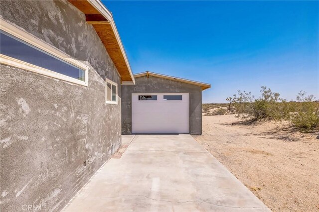 64515 Del Oro Rd, Joshua Tree, CA 92252 - view of home's exterior with driveway, stucco siding, and an attached garage