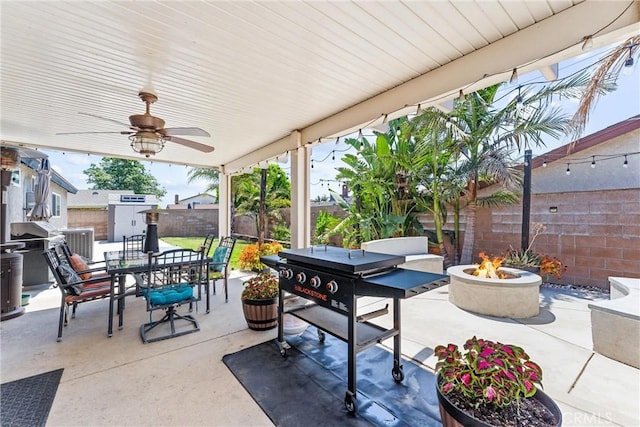 6057 Azalea St, Chino, CA 91710 - fenced backyard featuring an outdoor fire pit, a patio area, outdoor dining area, a ceiling fan, and a storage unit