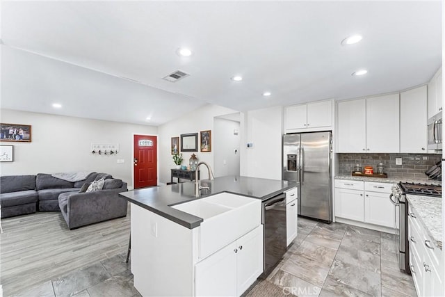 6057 Azalea St, Chino, CA 91710 - kitchen with stainless steel appliances, recessed lighting, an island with sink, decorative backsplash, and lofted ceiling