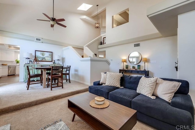 25322 Poderio Dr, Ramona, CA 92065 - living room with high vaulted ceiling, a ceiling fan, light colored carpet, a skylight, and stairs