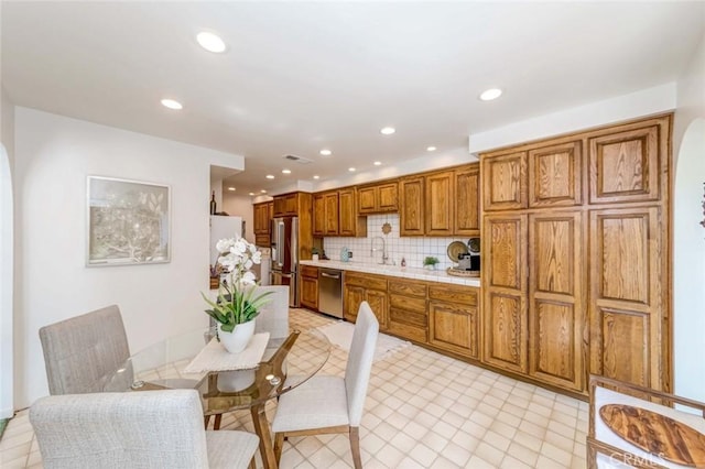 9858 Cullman Ave, Whittier, CA 90603 - kitchen featuring stainless steel appliances, brown cabinets, decorative backsplash, and recessed lighting