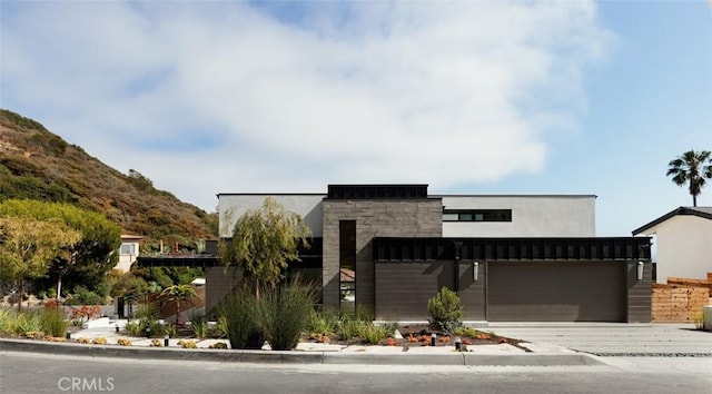 1105 Skyline Dr, Laguna Beach, CA 92651 - contemporary house with stone siding, driveway, and an attached garage