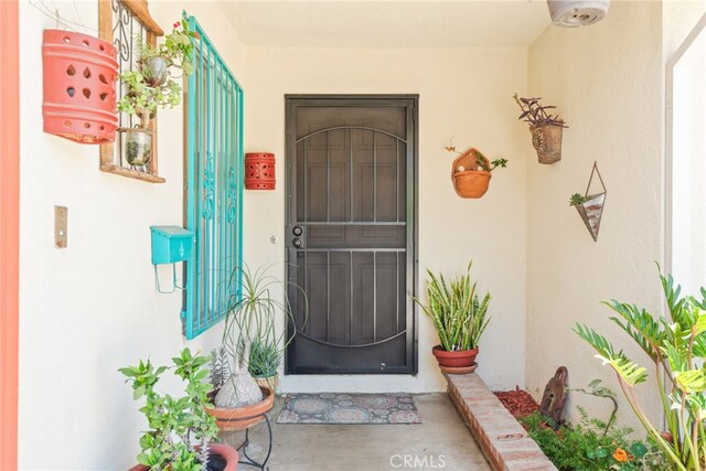 252 W Blaine St, Riverside, CA 92507 - doorway to property featuring stucco siding and covered porch