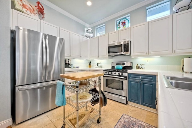6707 Ketch Way, Carlsbad, CA 92011 - kitchen with stainless steel appliances, ornamental molding, blue cabinets, white cabinetry, and light tile patterned flooring