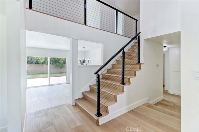 8312 Bellhaven St, La Palma, CA 90623 - stairway featuring wood finished floors, a high ceiling, and a chandelier