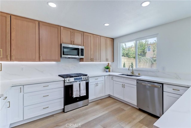 8312 Bellhaven St, La Palma, CA 90623 - kitchen featuring appliances with stainless steel finishes, recessed lighting, light wood-type flooring, tasteful backsplash, and light stone counters